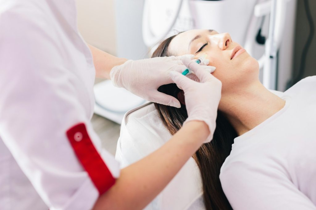 Injectable tissue stimulator on woman face in beauty salon